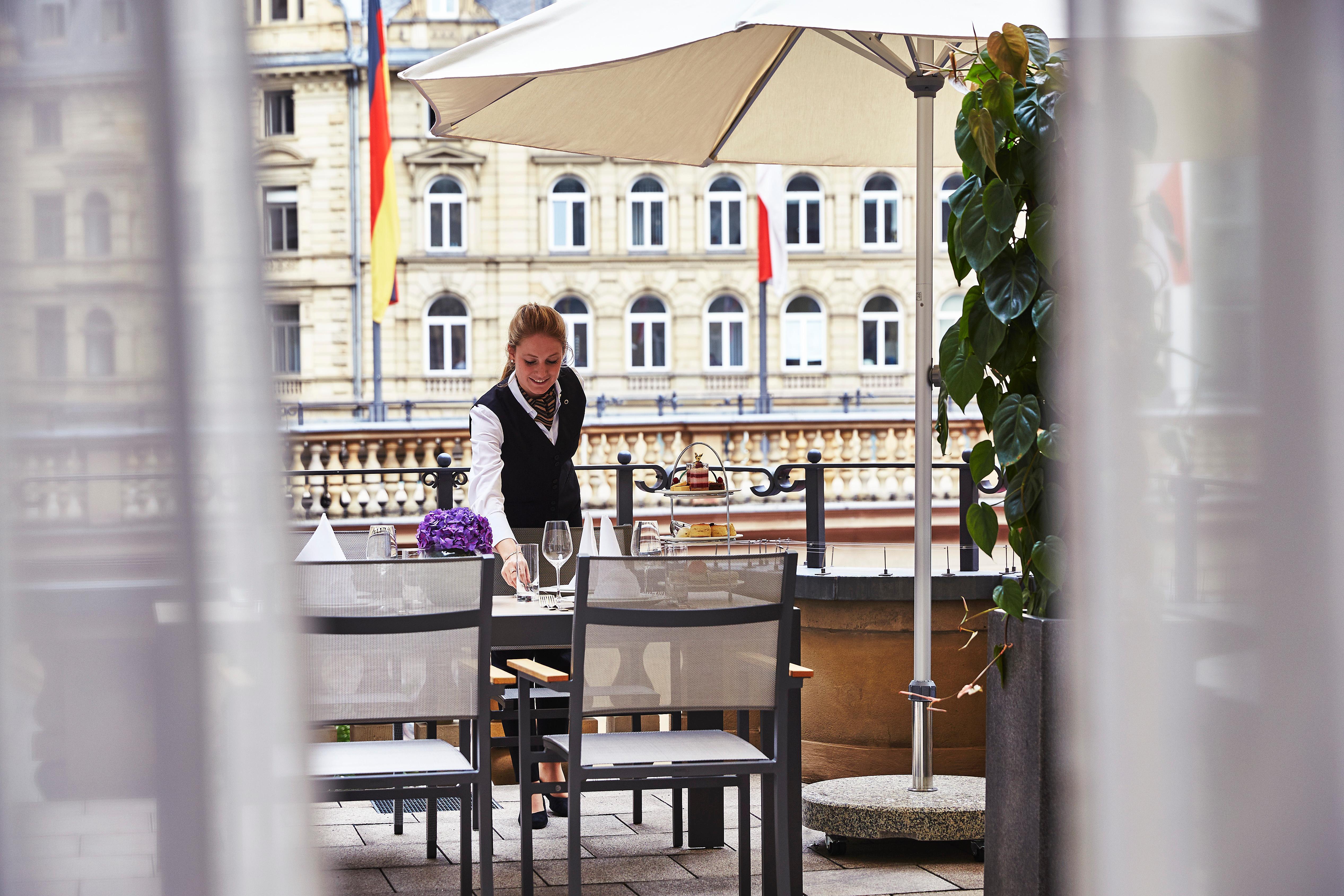 Steigenberger Icon Frankfurter Hof Hotel Frankfurt am Main Exterior foto A waitress clearing a table at a restaurant